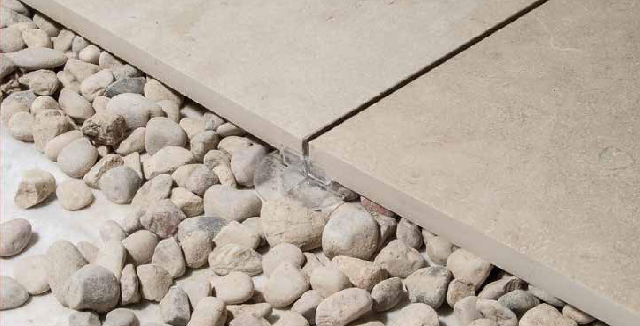 Tiles on gravel supported and spaced with StrataRise Clear Paver Support Spacers